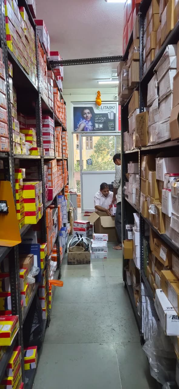 Shelves of switchgear stock along an aisle at Santosh Electricals