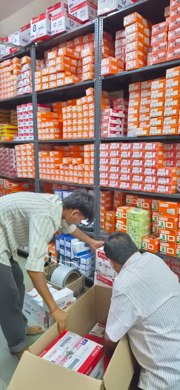 Staff checking product boxes against an order at Santosh Electricals